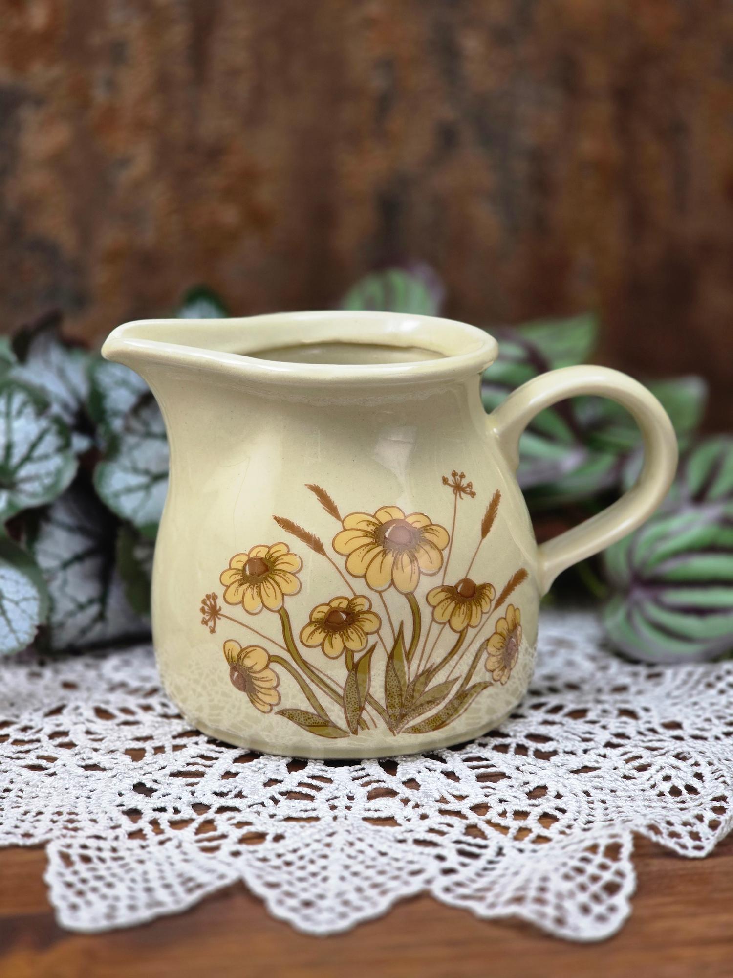 DDR Keramik Milchgießer aus dem Mala Geschirrset von VEB Sintolanwerk Annaburg mit gelbem Blumenmotiv, cremefarbener Glasur und klassischer 1970er Form.