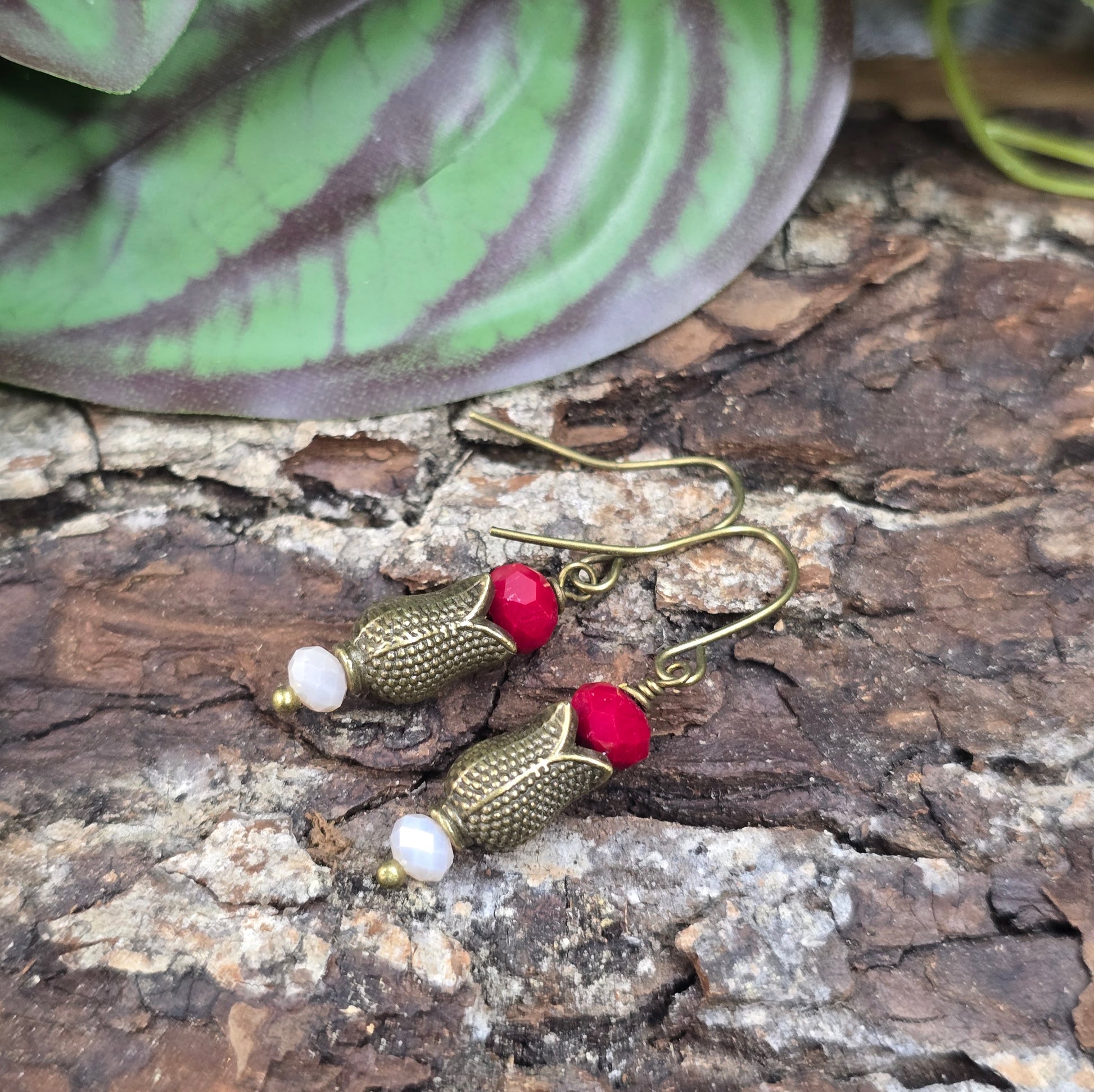 Romantische Ohrhänger im Nostalgie-Stil mit bronzefarbenem Tulpenkelch & dunkelroten Kristallglasperlen. Perfekt für Alltag, Date oder als liebevolles Geschenk für Schmuckliebhaber.