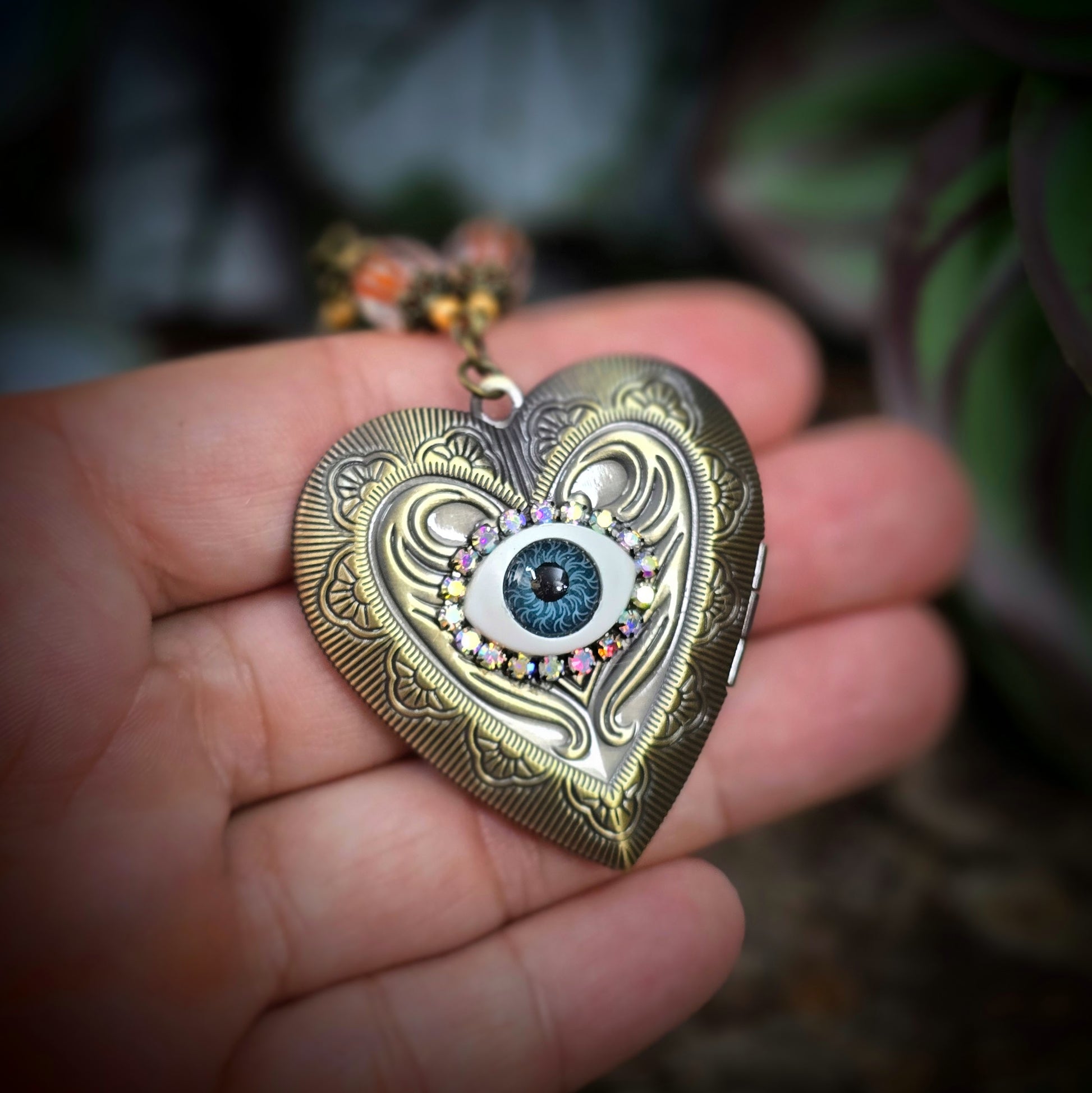 Herzmedaillon-Kette mit skurrilem Auge & Strass. Orange & Bronze, handmade & einzigartig. Mit Hakenverschluss & geheimnisvollem Look. Für alle, die das Besondere lieben.
