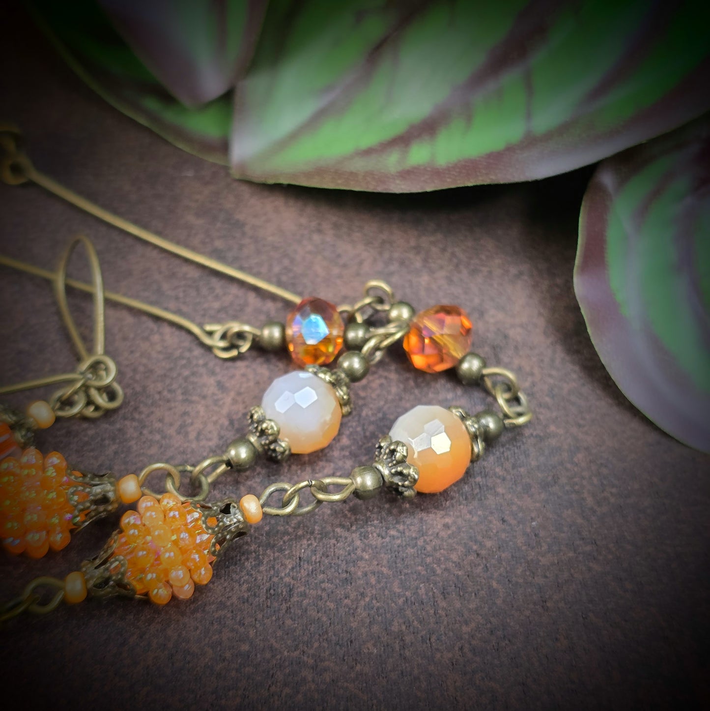 Herzmedaillon-Kette mit skurrilem Auge & Strass. Orange & Bronze, handmade & einzigartig. Mit Hakenverschluss & geheimnisvollem Look. Für alle, die das Besondere lieben.