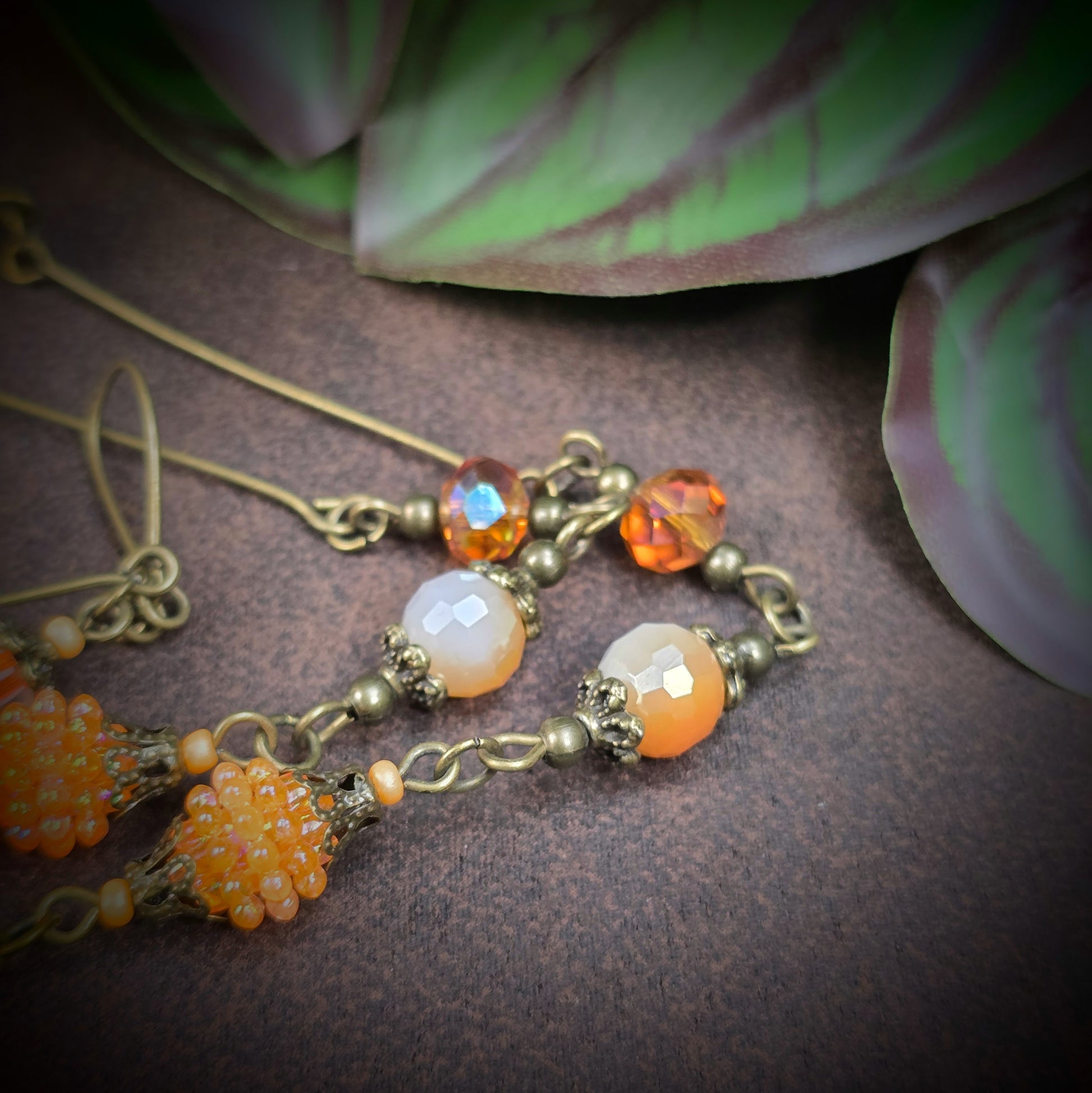 Herzmedaillon-Kette mit skurrilem Auge & Strass. Orange & Bronze, handmade & einzigartig. Mit Hakenverschluss & geheimnisvollem Look. Für alle, die das Besondere lieben.