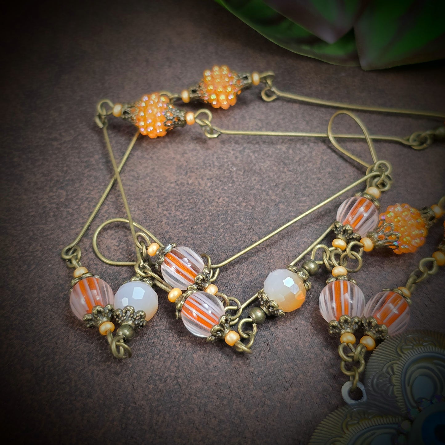 Herzmedaillon-Kette mit skurrilem Auge & Strass. Orange & Bronze, handmade & einzigartig. Mit Hakenverschluss & geheimnisvollem Look. Für alle, die das Besondere lieben.