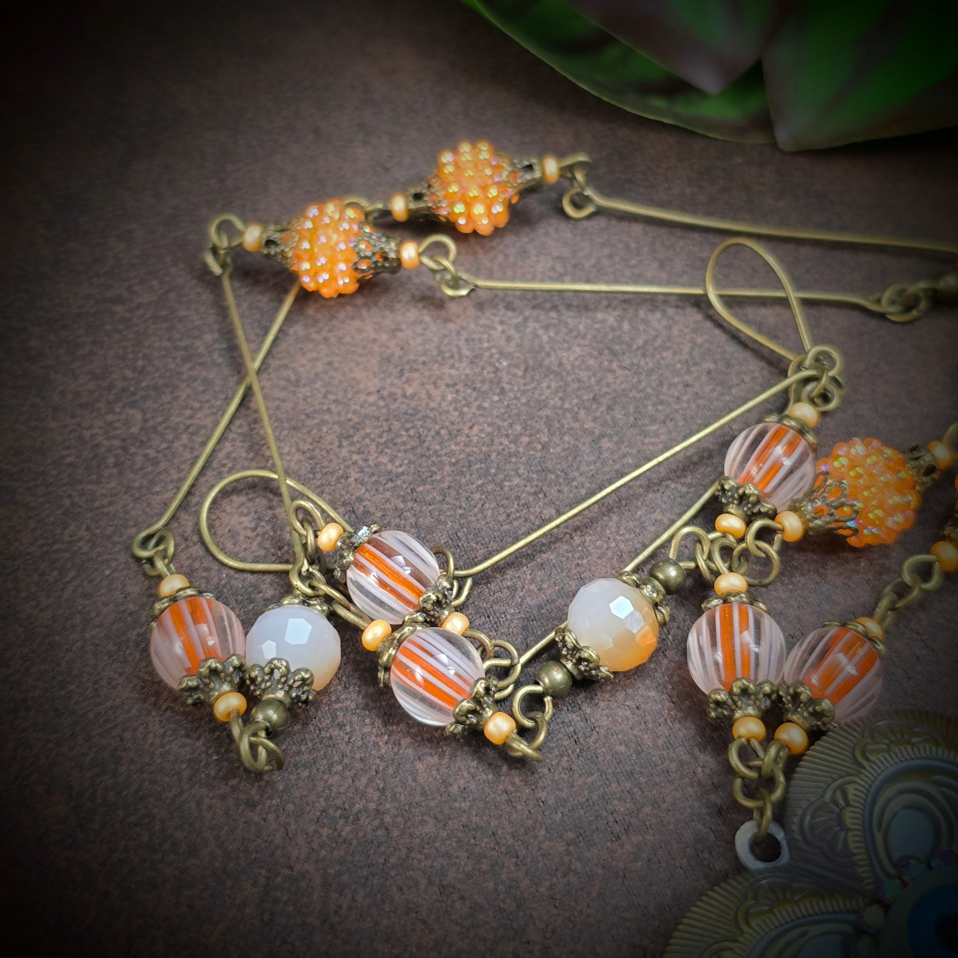 Herzmedaillon-Kette mit skurrilem Auge & Strass. Orange & Bronze, handmade & einzigartig. Mit Hakenverschluss & geheimnisvollem Look. Für alle, die das Besondere lieben.