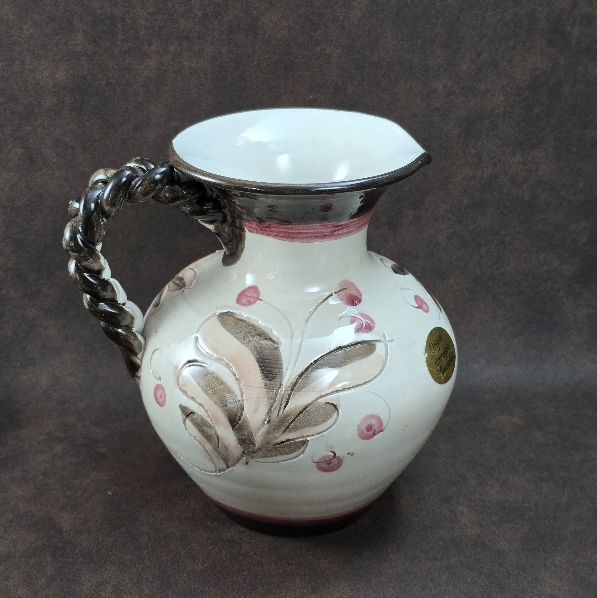Handbemalter italienischer Keramikkrug mit floralen Ornamenten und geflochtenem Henkel, Vintage ca. 1960er–1980er Jahre.