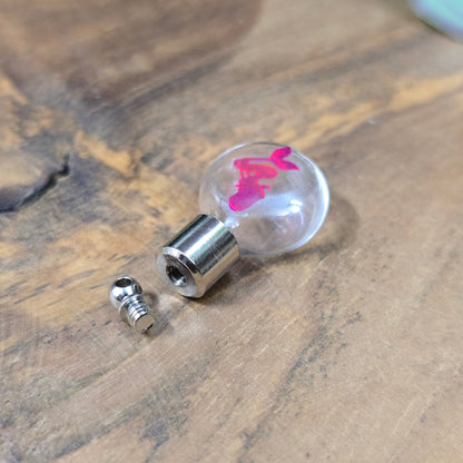 Kleine Glasflasche mit Schraubverschluss und pinkem Meerjungfrau-Motiv, ideal als Kettenanhänger und tragbare Parfümflasche.