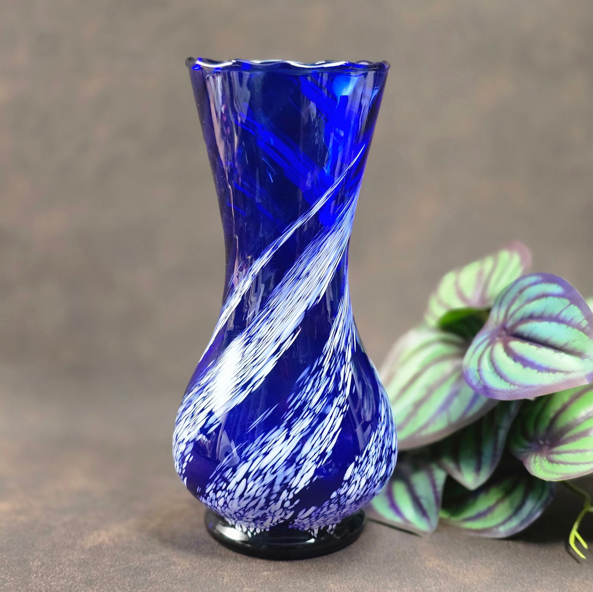 Mundgeblasene Vintage-Vase aus blauem Glas mit weißen Wirbeln, 19 cm hoch, 70er Jahre DDR. Authentisches Designobjekt mit kleinen Gebrauchsspuren.
