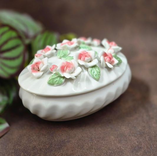 Romantische Schmuckdose aus Porzellan, weiß/rosé, 12,5×8,5×7 cm, ca. 304 g. Capodimonte-Look der 80er, ideal als Geschenk oder Deko. Ungemarkt, sehr gepflegt, bereit zum Einziehen.