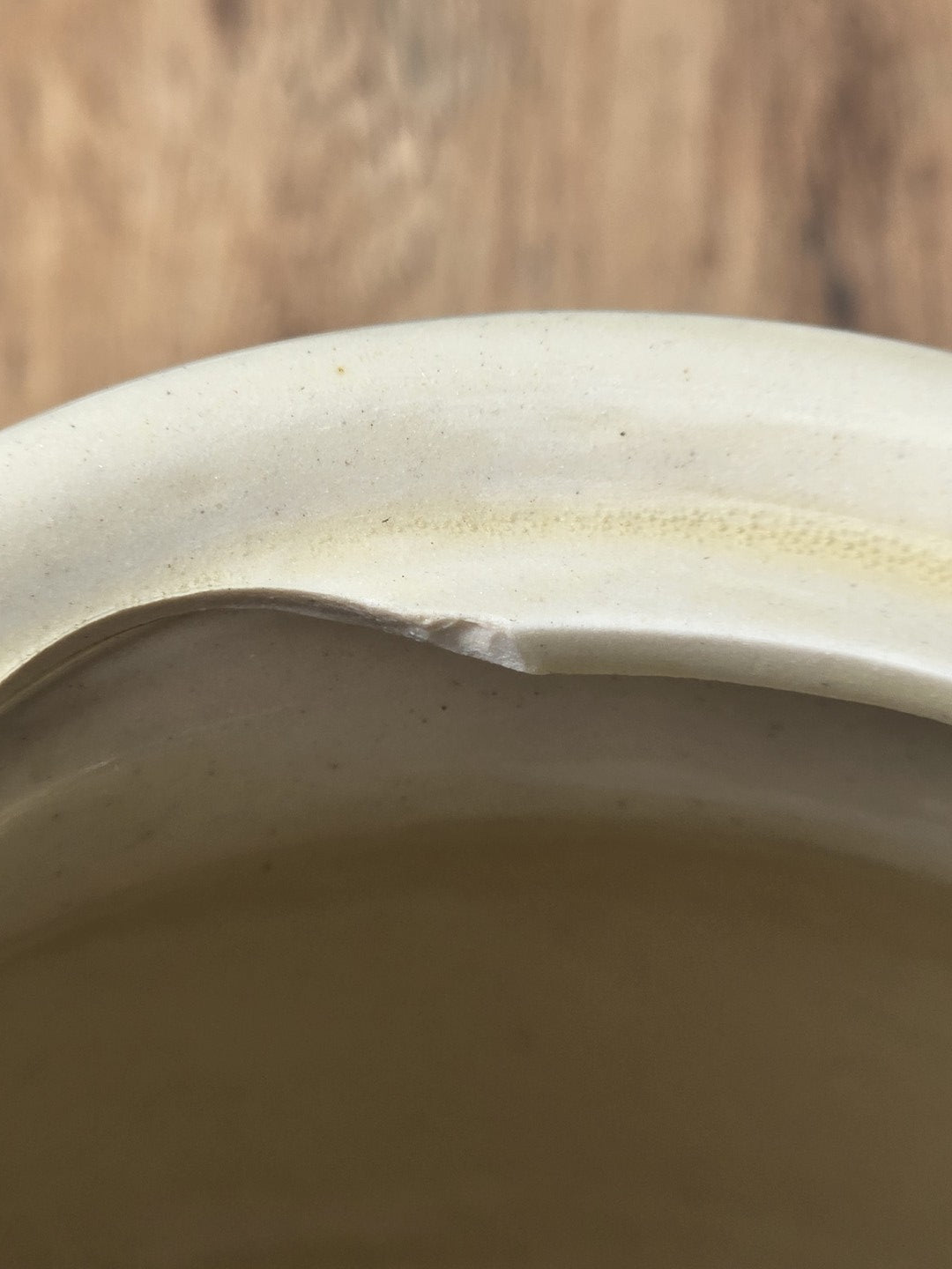 Innenansicht der cremeweißen Teekanne mit sichtbaren Gebrauchsspuren am Rand.