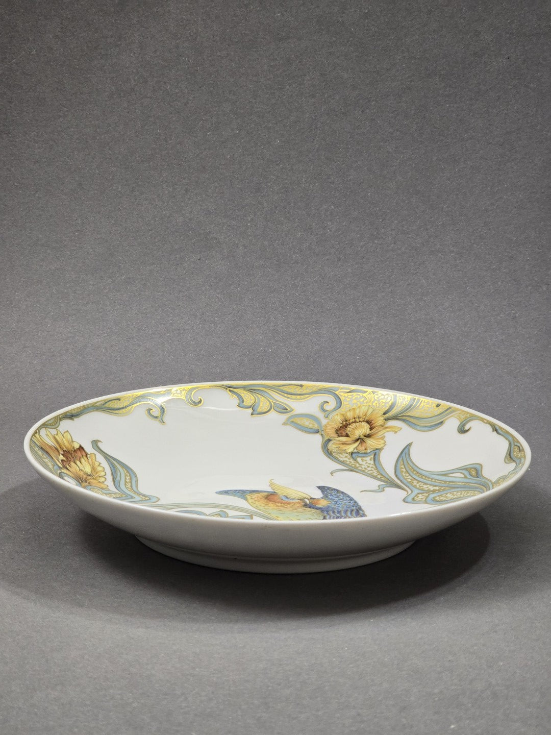 Vintage Kaiser Porzellanschale mit flacher runder Form, Vogelmotiv und blau-goldenem Dekor in seitlicher Profilansicht