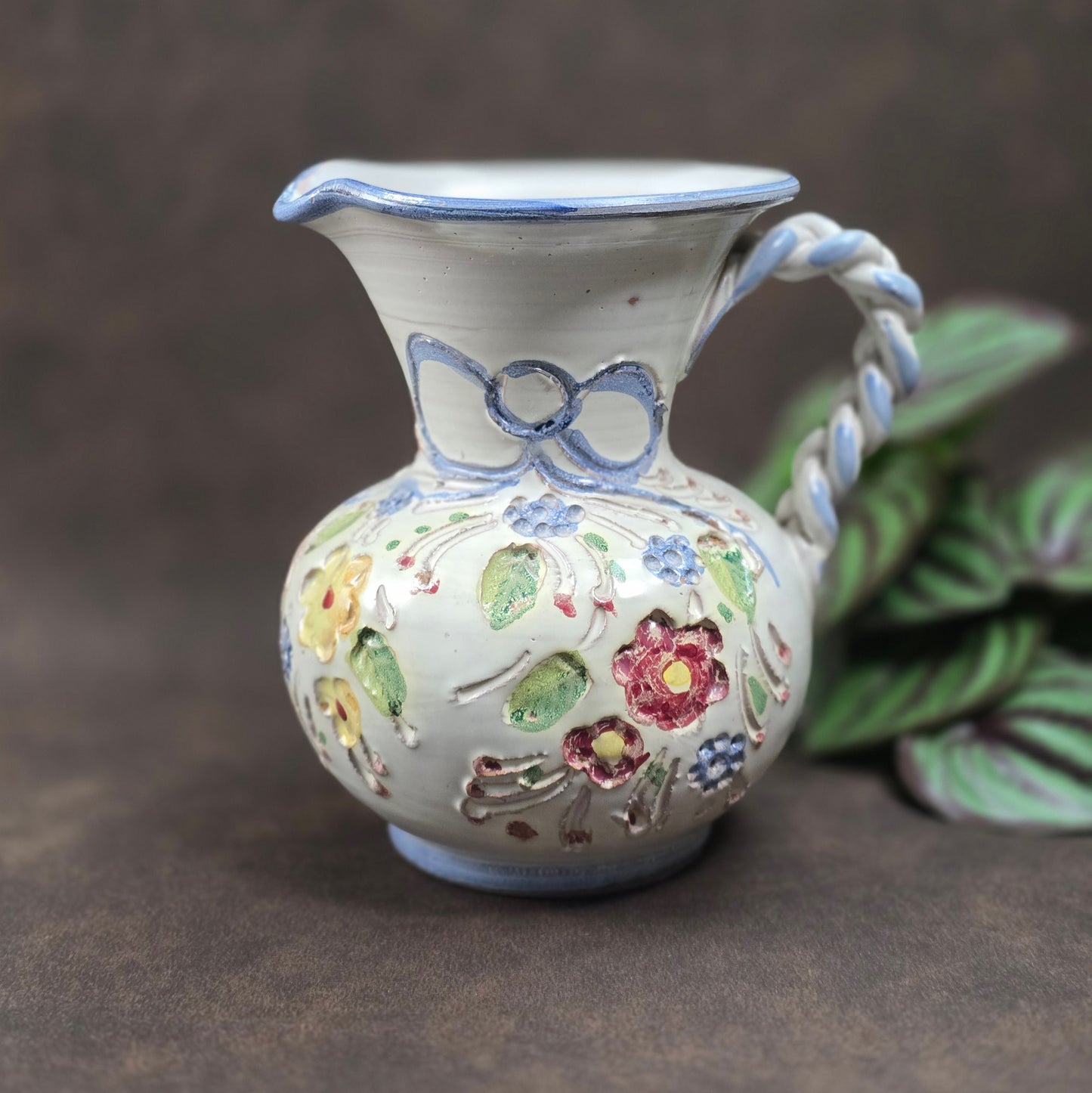 Vintage-Krug von Ainring Keramik, 1970er Jahre. Handarbeit mit Blumendekor & geflochtenem Griff. Leichte Unregelmäßigkeiten – ein echtes Unikat mit Charme!

