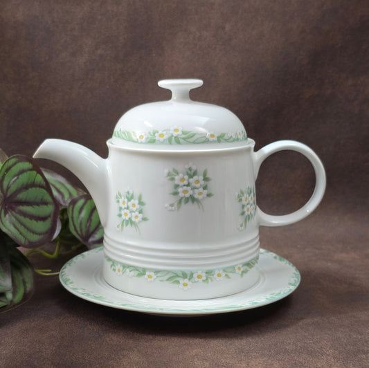 Kleine Vintage-Kaffeekanne aus Porzellan von Melitta Friesland, inkl. Teller. Fröhliches Blümchendekor, ideal für Kaffee- oder Teegenuss.