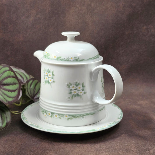 Kleine Vintage-Kaffeekanne aus Porzellan von Melitta Friesland, inkl. Teller. Fröhliches Blümchendekor, ideal für Kaffee- oder Teegenuss.