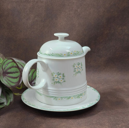 Kleine Vintage-Kaffeekanne aus Porzellan von Melitta Friesland, inkl. Teller. Fröhliches Blümchendekor, ideal für Kaffee- oder Teegenuss.