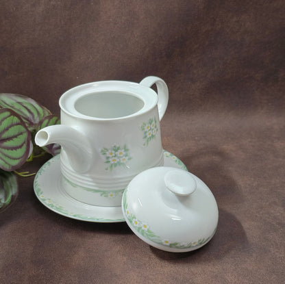 Kleine Vintage-Kaffeekanne aus Porzellan von Melitta Friesland, inkl. Teller. Fröhliches Blümchendekor, ideal für Kaffee- oder Teegenuss.
