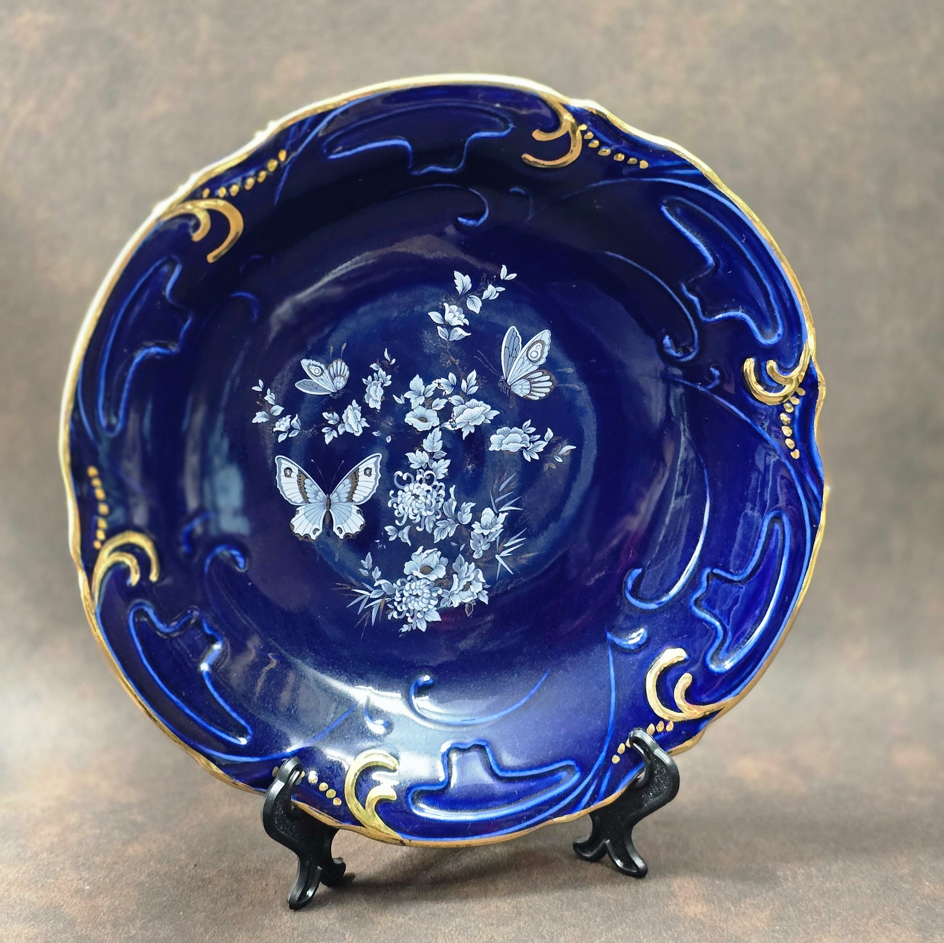 Rumänischer Arpo Porzellan-Zierteller, handbemalt in Kobaltblau mit Schmetterlingen und Goldrand, Ø 24 cm, 1970er Jahre.