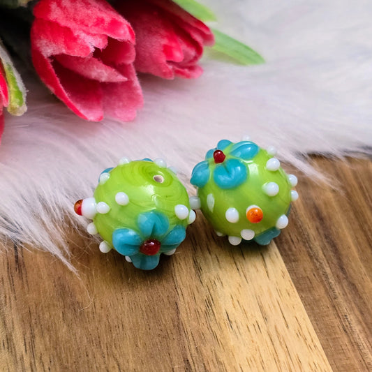 Zwei grüne Glasperlen mit Blumenmuster & Bumps – handgefertigt in Indien. Ideal für Ketten, Armbänder & mehr. Jede Perle ein Unikat!