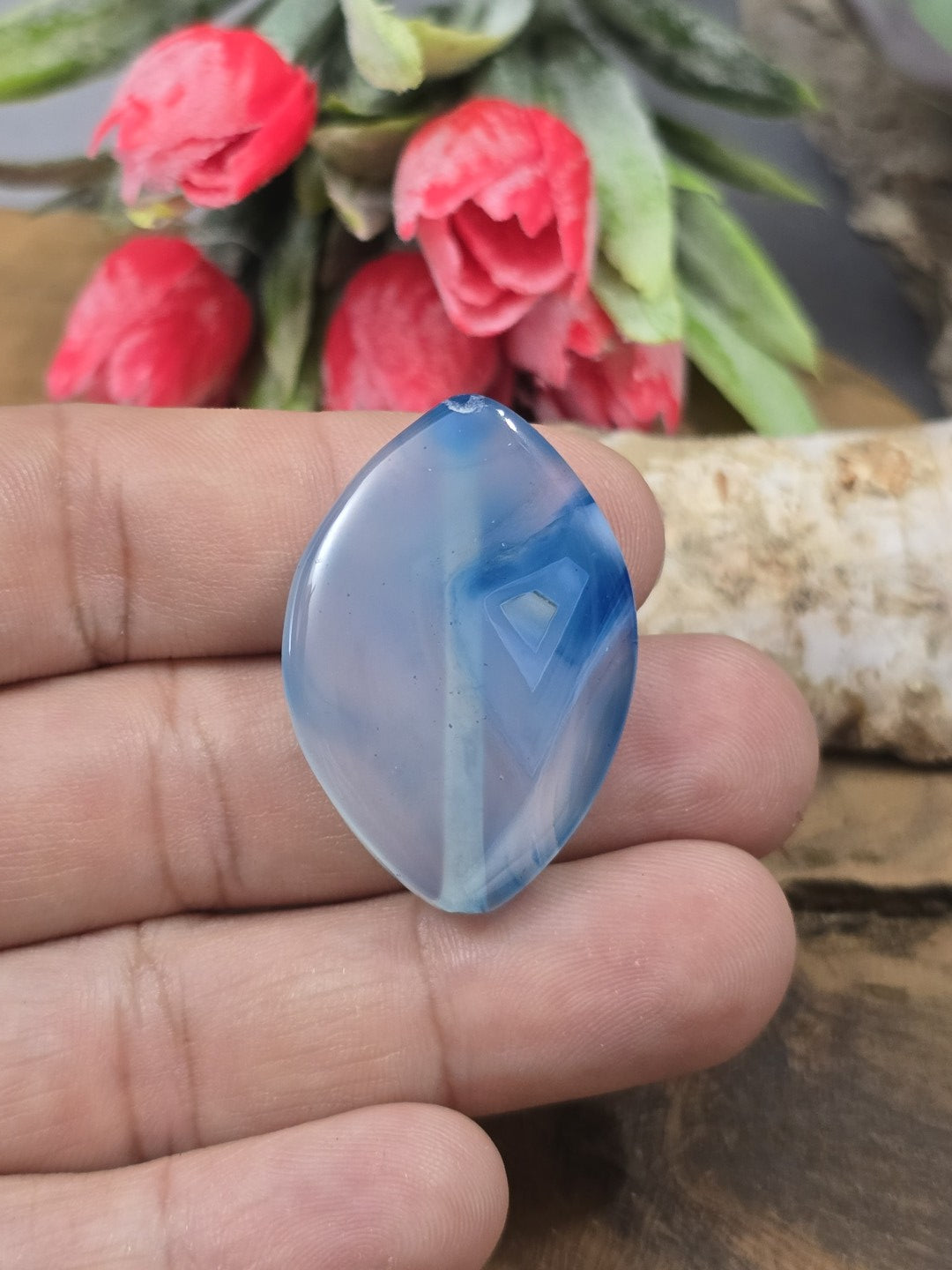 Achat-Perle in Navette-Form (34x24 mm) in strahlendem Blau auf einer Handfläche als praktischer Größenvergleich für DIY-Schmuck.