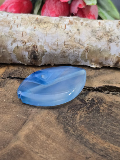 Seitenansicht der blauen Achat-Navetteperle (34x24 mm) mit sichtbarer Bohrung für Draht und Fädelmaterial.