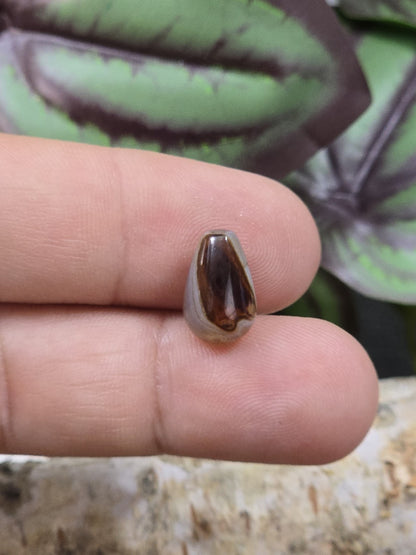 Braune Achat-Tropfenperle mit feiner Bänderung als Größenvergleich auf den Fingern für DIY-Schmuck
