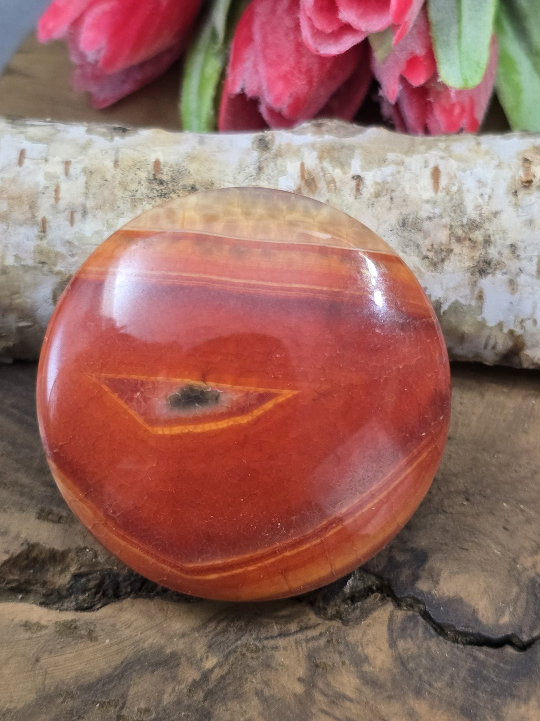 Rückseite der runden Achat-Perle in intensivem Rot-Orange mit charakteristischem Augenmuster.