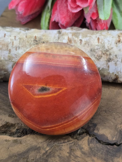 Rückseite der runden Achat-Perle in intensivem Rot-Orange mit charakteristischem Augenmuster.