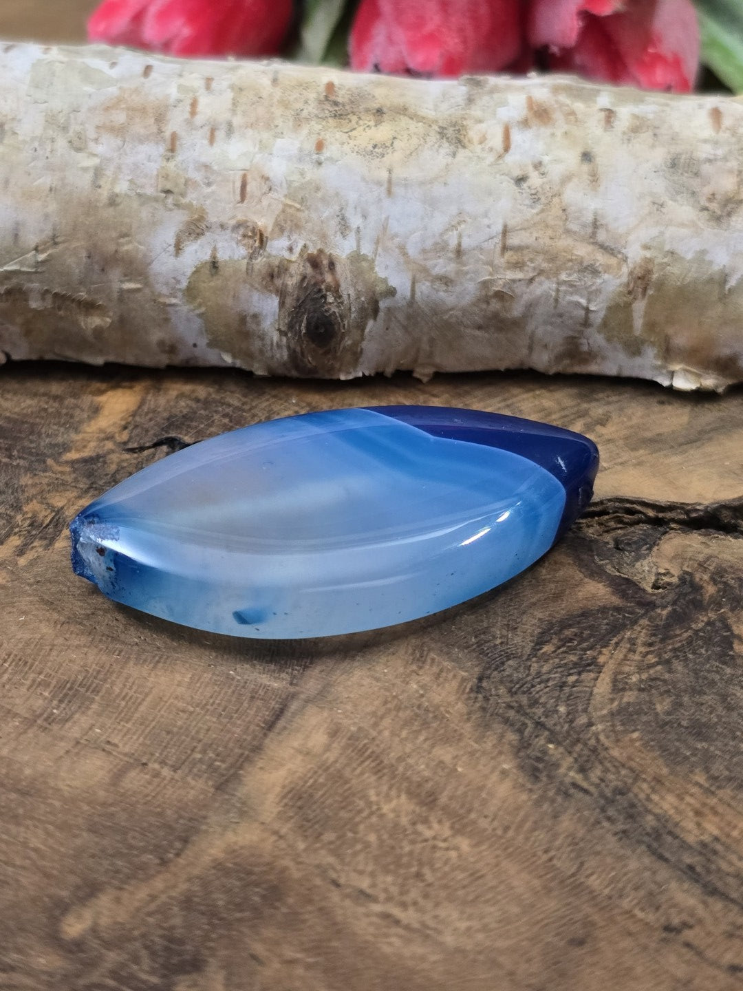 Flache Seitenansicht der blauen 39 mm Achat-Perle zur Veranschaulichung der Steindicke und der Längsbohrung.