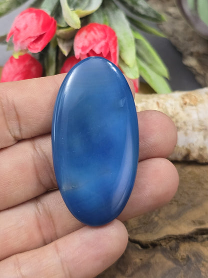Große blaue Achat-Navetteperle (50 mm) auf der Handfläche gehalten als Größenvergleich für die Schmuckherstellung.