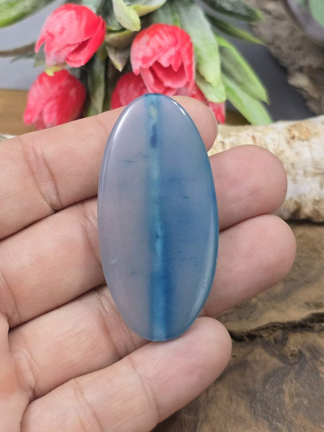 Große blaue Achat-Navetteperle (51 mm) auf der Handfläche als Größenvergleich für Statement-Schmuckstücke.