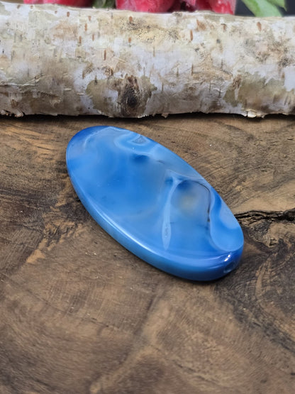 Seitliche Perspektive der flach liegenden gemusterten Achat-Navetteperle in Blau mit sichtbarem Loch-Eingang.
