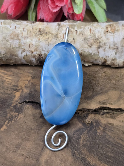 Blau gemusterte Achat-Centerperle (50 mm) auf silbernem Schmuckdraht aufgefädelt als Anwendungsbeispiel für Anhänger.