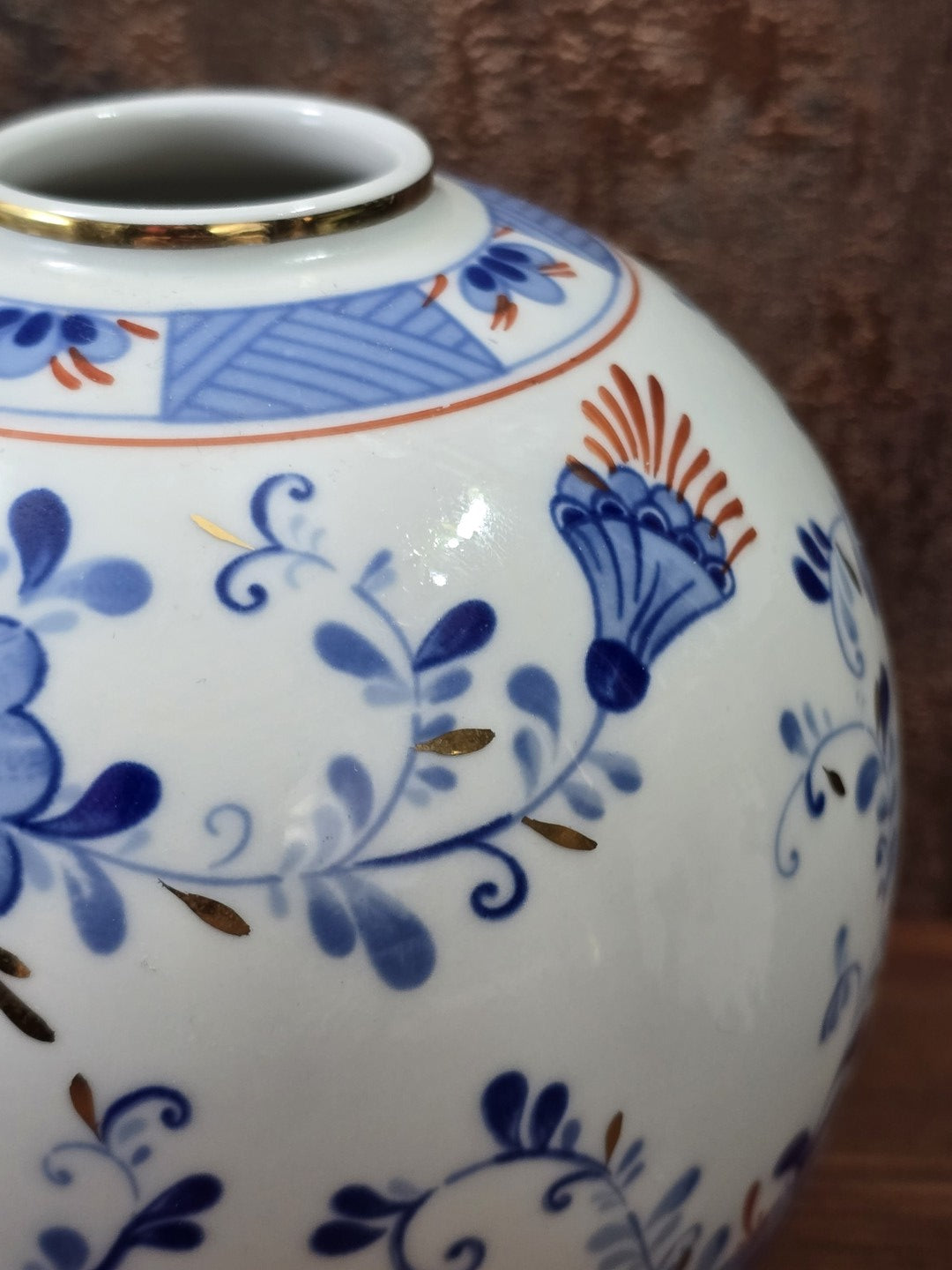 Vintage Porzellanvase mit blauem Blüten- und Rankendekor, Goldakzenten und goldgerändertem Hals in detailreicher Nahaufnahme