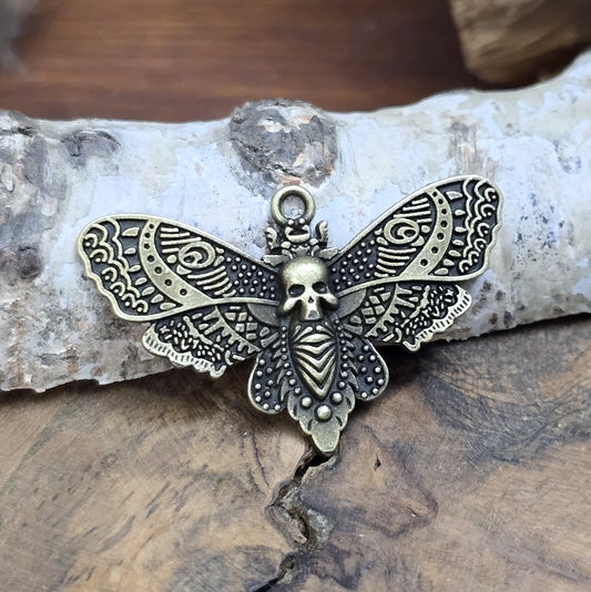 Das Bild zeigt einen Anhänger im antik bronzefarbenen Look. Mit einer Breite von 27 mm und einer stabilen Öse eignet er sich perfekt für die Gestaltung von Ketten, Chokern oder anderen individuellen Schmuckstücken.