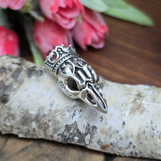 Das Bild zeigt einen Anhänger Krähenschädel, Rabenschädel &nbsp;mit Krone, antik silberfarbig, 33mm

... für einen mystischen und zeitlosen Look.

Der Anhänger hat oben am Schädel eine feste Öse und eignet sich hervorragend für die individuelle Schmuckherstellung.