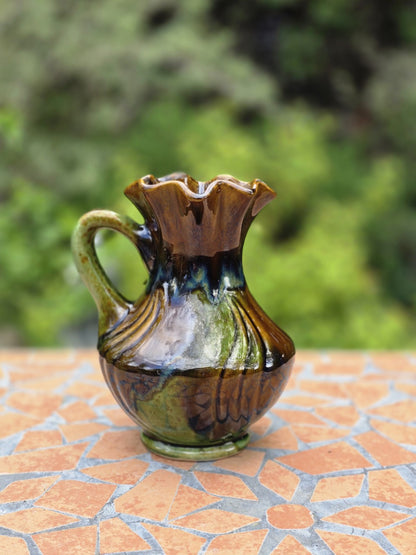 Bay Keramik Henkelvase aus West Germany mit braun-grünem Glasurverlauf, bauchiger Form, gerüschter Öffnung und ca. 17 cm Höhe.