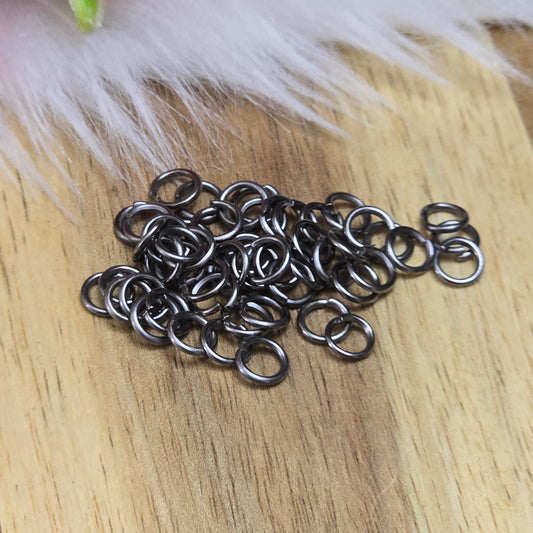 Das Bild zeigt 50 offene Biegeringe in gunmetal black. Die Ringel sind ein unverzichtbares Zubehör für die Schmuckherstellung. Ideal um Charms und Verschlüsse zuverlässig zu befestigen.