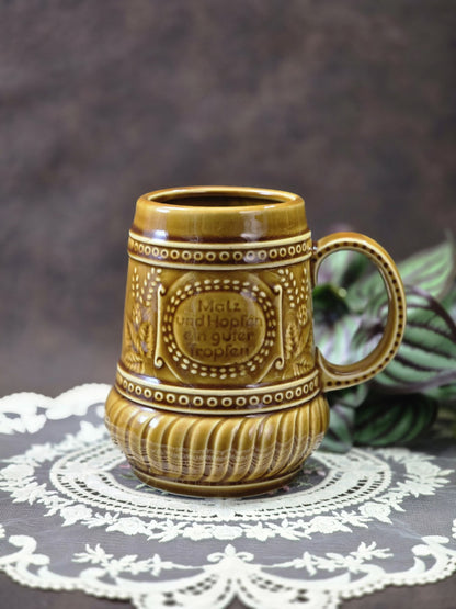 Vintage Steingut Bierkrug mit brauner Glasur, Henkel, Reliefdekor und Spruch „Malz und Hopfen ein guter Tropfen“