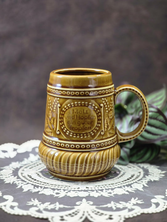 Vintage Steingut Bierkrug mit brauner Glasur, Henkel, Reliefdekor und Spruch „Malz und Hopfen ein guter Tropfen“