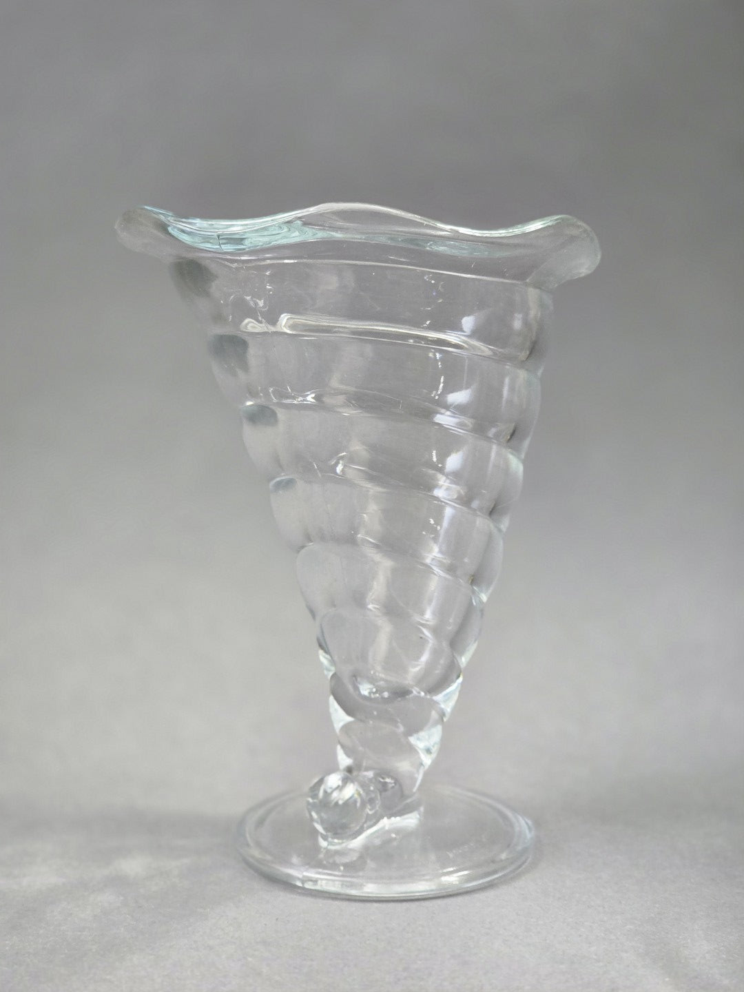 Rückansicht eines transparenten Bormioli Rocco Fortuna Eisbechers mit spiralförmigem Glasdekor, rundem Fuß und leicht welligem Rand.