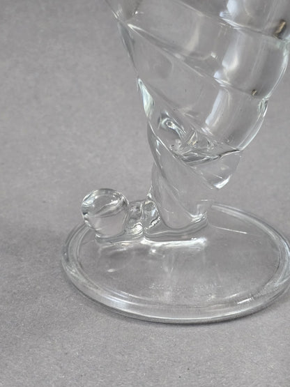 Nahaufnahme vom unteren Bereich des Eisbechers mit rundem Standfuß, kurzem Stiel, spiralförmigem Glasdekor und kleinem Glasknopf am Fuß.