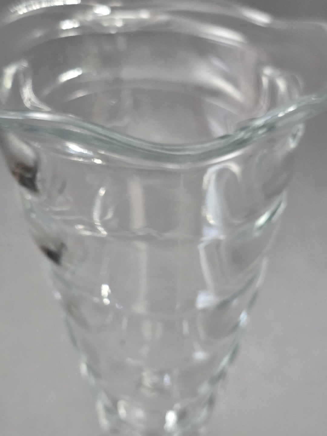 Detailaufnahme des geschwungenen Randes am klaren Fortuna Eisbecher, mit sichtbarer Glasstärke, Reflexionen und kleiner Unregelmäßigkeit am Rand.