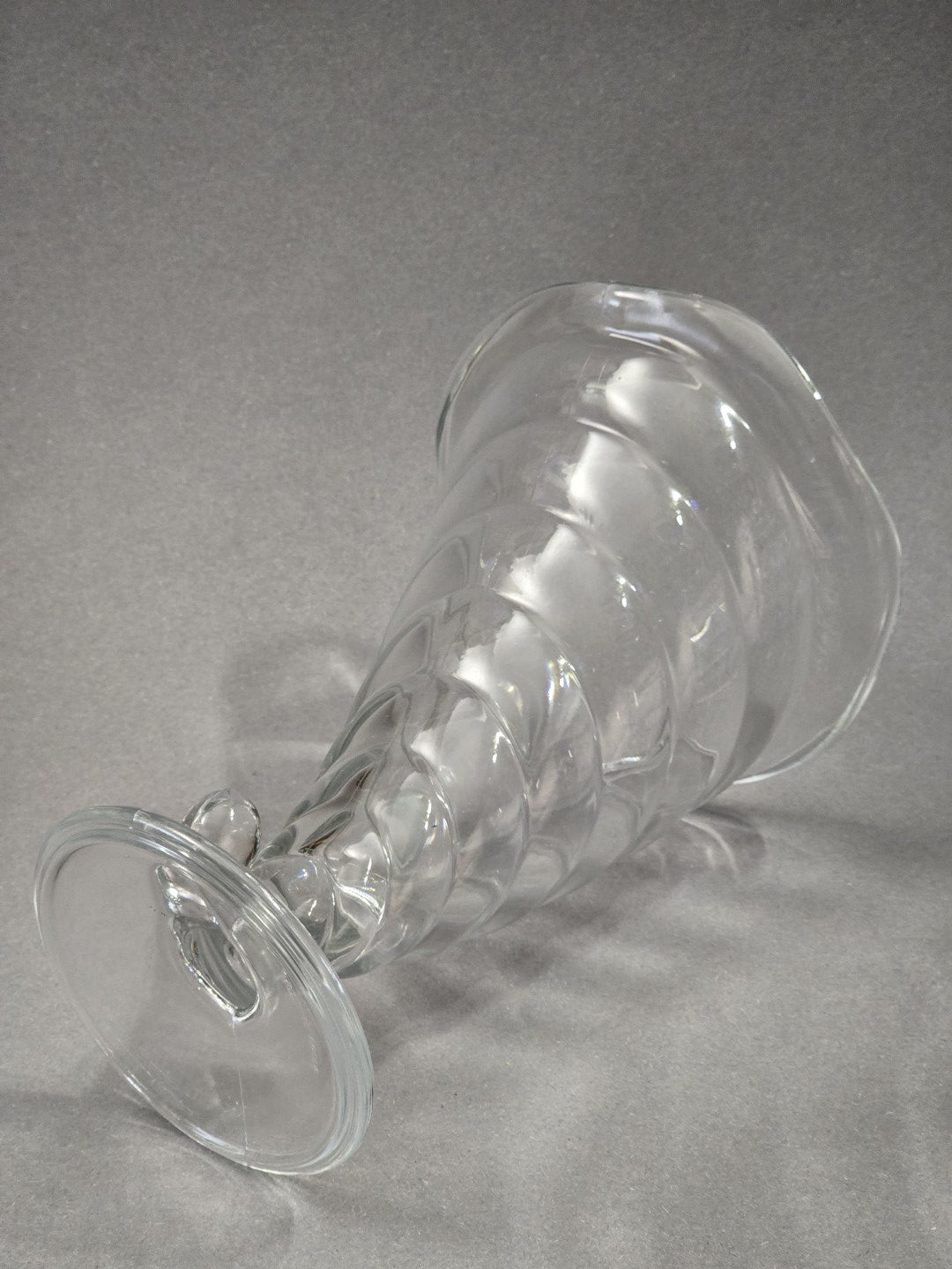 Ein transparenter Bormioli Rocco Fortuna Eisbecher liegt seitlich, sodass runder Fuß, gedrehter Kelch, welliger Rand und Glasform sichtbar sind.