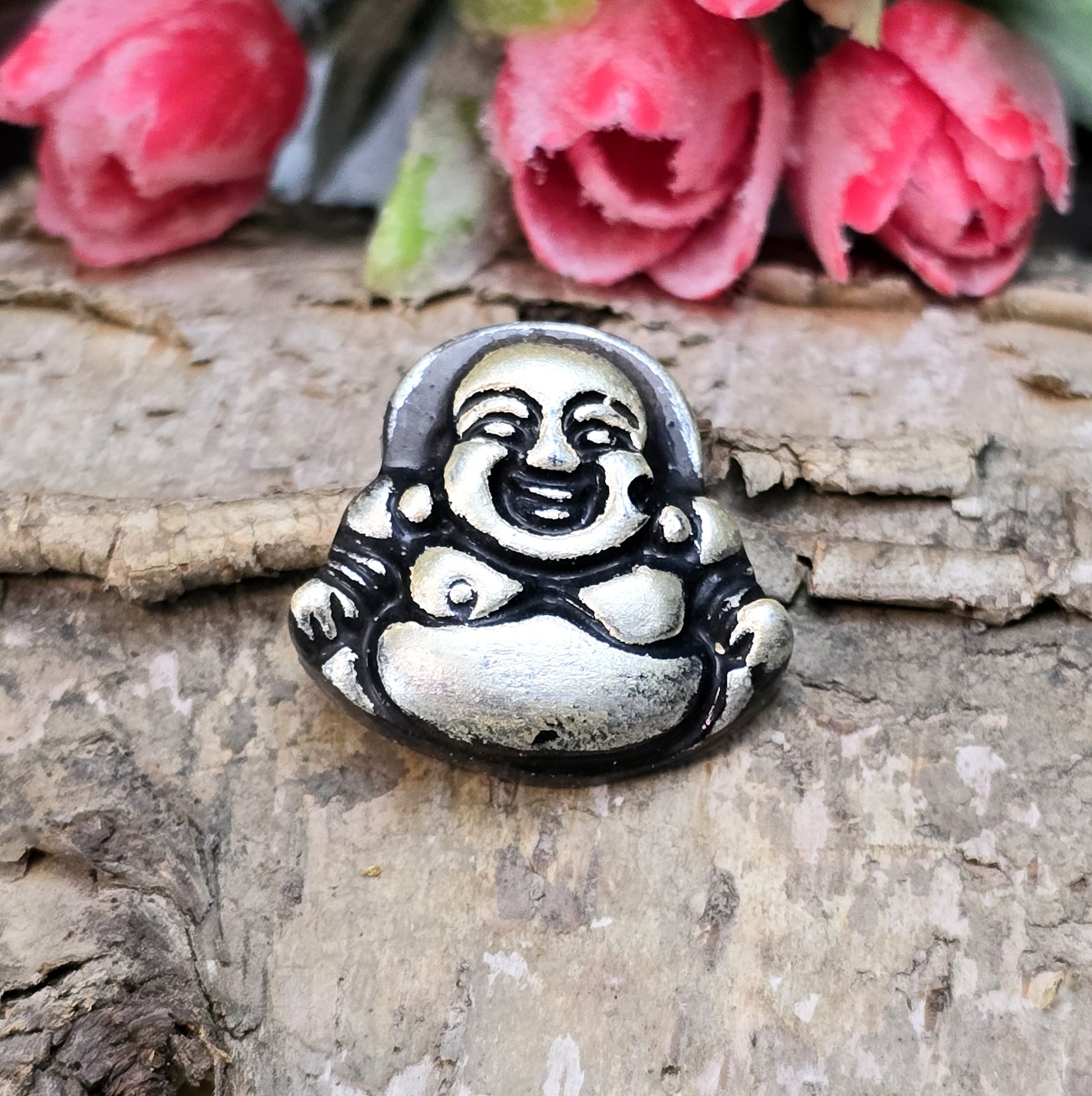 Das Bild zeigt einen handgefertigten Anhänger in Form eines lachenden Buddhas, gefertigt aus schwarzem Kunstharz mit roségoldenen Details. Der Buddha hat eine flache Rückseite und ein kleines Loch im oberen Bereich für eine Anhängeröse. Der Anhänger eignet sich hervorragend für Schmuckkreationen, Bastelprojekte oder zum Verzieren von Dekorationen.