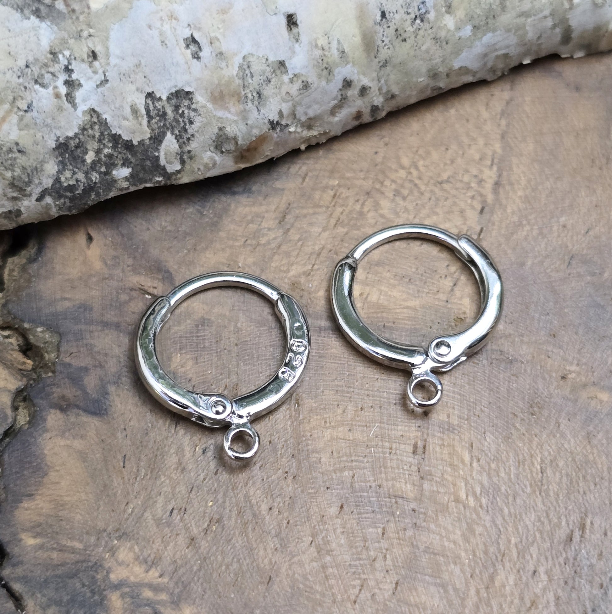 Das Bild zeigt Creolen mit Anhängeröse. Sie sind exquisite Schmuckstücke, die aus 925er Silber gefertigt sind. Mit einem Durchmesser von 13 mm (außen) sind sie elegant und perfekt für den täglichen Gebrauch oder besondere Anlässe.