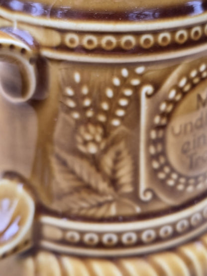 Florales Reliefdekor mit Hopfenmotiv und Punktmuster auf braunem Vintage Bierkrug