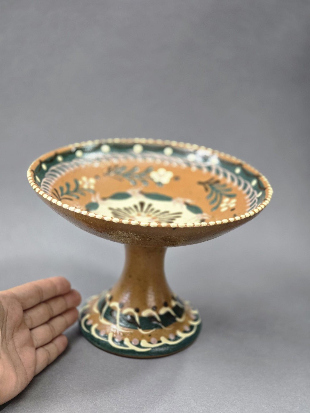 Vintage Keramik-Fußschale mit breiter Schale, hohem Standfuß und mehrfarbigem Dekor, seitlich mit Hand als Größenvergleich