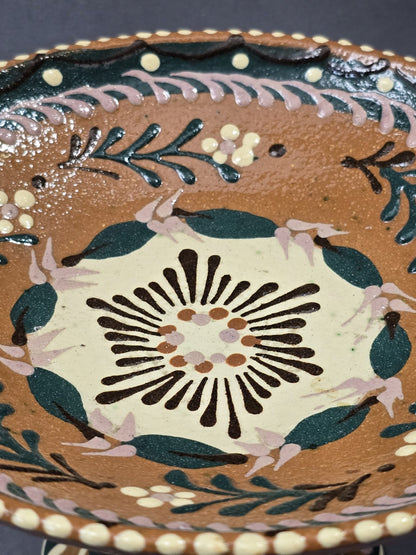 Vintage Keramik-Fußschale mit großem cremefarbenem Blütenmotiv, grünen Blättern und rosa Akzenten in Nahaufnahme der Schalenmitte