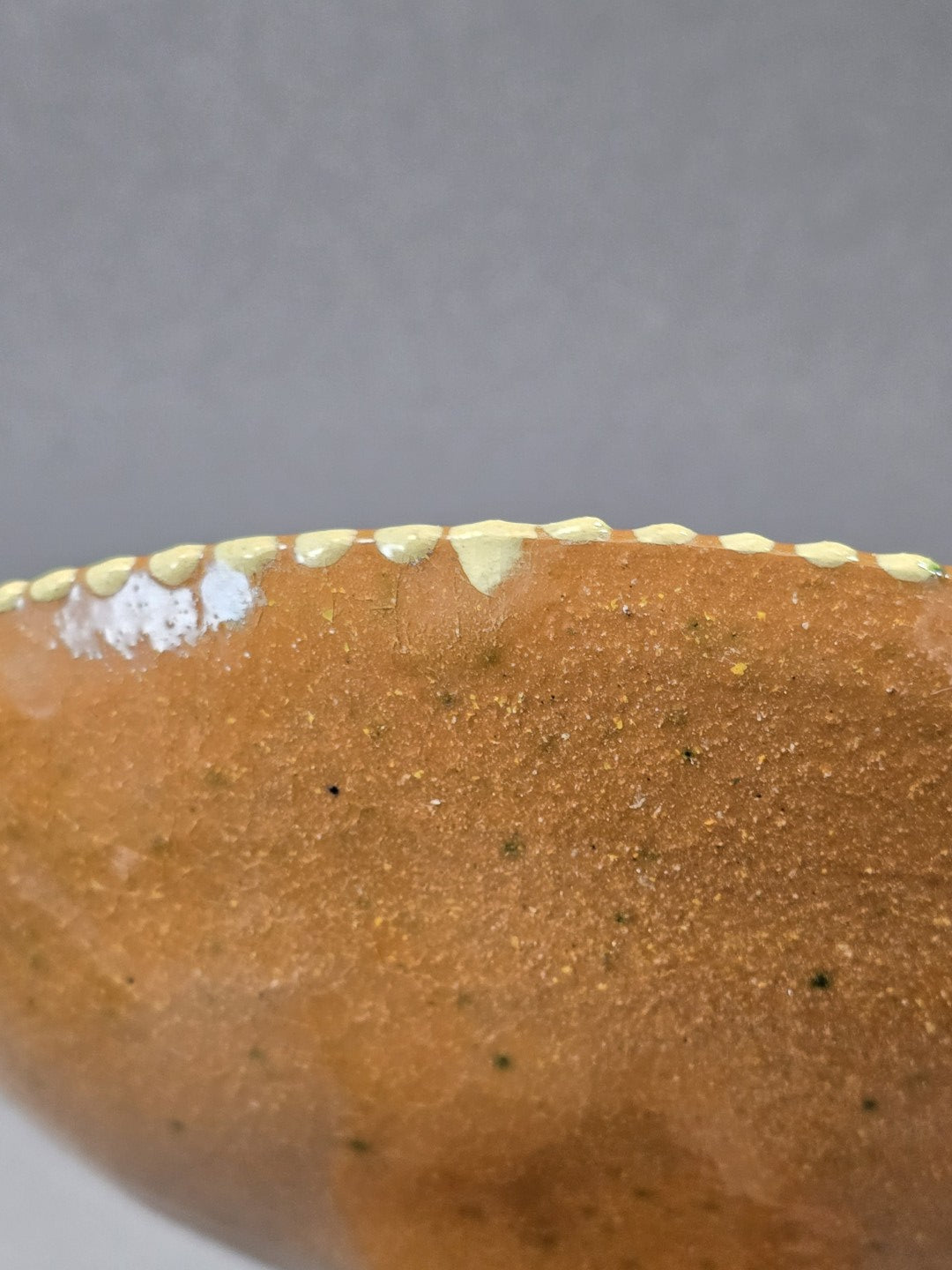 Vintage Keramik-Fußschale mit brauner Unterseite und cremefarben bemaltem Rand, Detailaufnahme der Kante und strukturierten Oberfläche