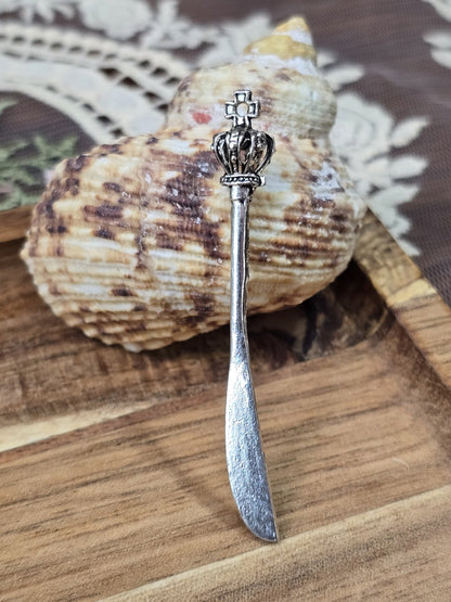 Gothic-Dolch-Anhänger mit Kronenknauf und Kreuz aufgestellt vor einer Muschel für Schmuckherstellung.