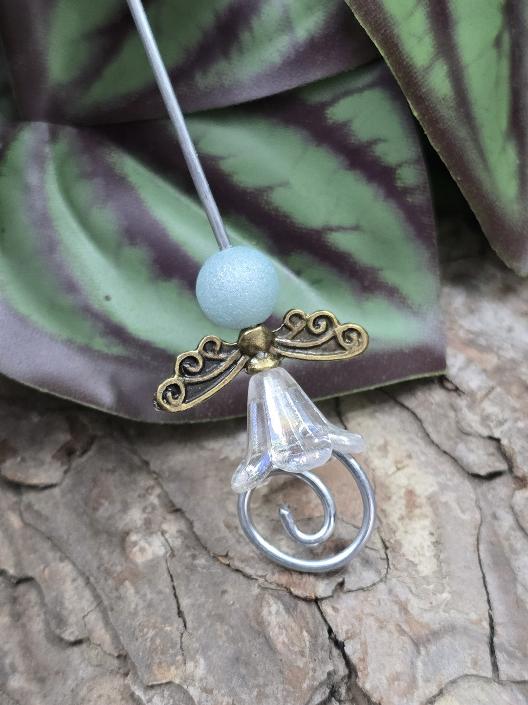 Bastelbeispiel für einen Schutzengel-Anhänger mit antiker Bronze-Flügelperle, blauer Kopfperle und Blütenkelch
