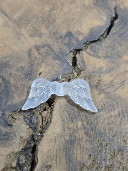 Einzelne gefrostete weiße Flügelperle aus Acryl im Detail mit geprägter Federstruktur.
